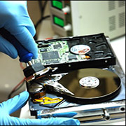 hard-disk-aperto-con-mani-guantate-che-riparano